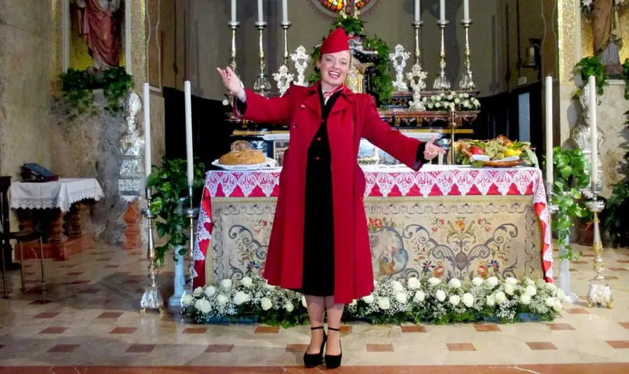 Fiona Harrison in a red coat and hat at a festive table